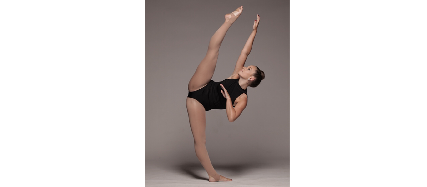 A dancer stretching a leg and arm upward.